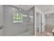 Modern glass-enclosed shower, with tile walls, and neutral flooring; adjoining toilet at 803 Allison Place, Bartow, FL 33830