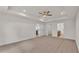 Spacious carpeted bedroom with tray ceiling, ceiling fan, and doorways to an en-suite bathroom and walk-in closet at 803 Allison Place, Bartow, FL 33830
