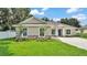 Beautiful single-story home featuring a well-manicured lawn, stone accents, and a stylish, modern design at 803 Allison Place, Bartow, FL 33830