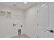 Well-lit laundry room with neutral finishes, storage shelf, and a white door at 803 Allison Place, Bartow, FL 33830