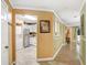 Open interior view showcasing the kitchen, laundry area, and hallway with hardwood floors at 8838 Coral Palms Ct # A, Kissimmee, FL 34747