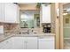 A kitchen featuring white cabinets, stainless steel sink, and views into other living areas at 8838 Coral Palms Ct # A, Kissimmee, FL 34747