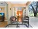 Charming patio features wicker chairs, a table and a view to a bedroom and green foliage at 8838 Coral Palms Ct # A, Kissimmee, FL 34747