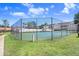 Community tennis court enclosed with tall fencing on a bright day with blue skies and fluffy clouds at 8838 Coral Palms Ct # A, Kissimmee, FL 34747
