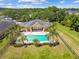 Aerial view showcasing a home, pool, patio, and lush landscaping at 1049 Stoney Creek Dr, Lakeland, FL 33811