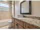 Bathroom featuring granite countertop, wooden cabinets, and a shower-tub combination at 1049 Stoney Creek Dr, Lakeland, FL 33811