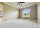 Bedroom featuring plush carpeting, a ceiling fan, and a window overlooking green space at 1049 Stoney Creek Dr, Lakeland, FL 33811