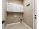 Functional laundry room with overhead cabinets and tile flooring at 1049 Stoney Creek Dr, Lakeland, FL 33811