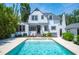 Backyard pool area with tiled pool, white home exterior, green hedges, and patio at 112 Hiawatha Trl, Lakeland, FL 33803