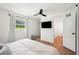 Bright bedroom with light wood floors, neutral linens, ceiling fan, and an ensuite bathroom at 112 Hiawatha Trl, Lakeland, FL 33803