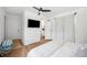 Bright bedroom with light wood floors, neutral linens, ceiling fan, and an ensuite bathroom at 112 Hiawatha Trl, Lakeland, FL 33803