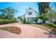 Charming two-story home with a red brick circular driveway and landscaped front yard at 112 Hiawatha Trl, Lakeland, FL 33803