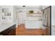 Bright kitchen featuring white cabinets, open shelving, stainless steel appliances, and hardwood floors at 112 Hiawatha Trl, Lakeland, FL 33803