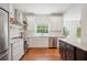 Bright, updated kitchen featuring stainless steel appliances, white cabinets, open shelves, and a dark kitchen island at 112 Hiawatha Trl, Lakeland, FL 33803
