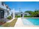 Backyard pool area with tiled pool, white home exterior, green hedges, and patio at 112 Hiawatha Trl, Lakeland, FL 33803