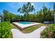 Backyard showcasing the pool with brick surround, landscaping, and manicured grounds at 112 Hiawatha Trl, Lakeland, FL 33803