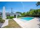 Backyard pool area with tiled pool, white home exterior, green hedges, and patio at 112 Hiawatha Trl, Lakeland, FL 33803