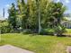 Well-maintained backyard featuring lush green grass and a variety of trees and plants, all enclosed by a chain-link fence at 117 Palmola St, Lakeland, FL 33803
