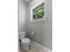 Bathroom with a standard toilet next to a window with view at 117 Palmola St, Lakeland, FL 33803