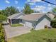 Exterior view of home featuring a two-car garage, screened porch, well-manicured lawn, and private driveway at 117 Palmola St, Lakeland, FL 33803