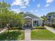 Inviting single-story home with a well-manicured lawn, landscaping, and a charming covered porch at 117 Palmola St, Lakeland, FL 33803
