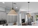 Well-lit living room features pendant lights, neutral paint, and an open concept to the kitchen at 117 Palmola St, Lakeland, FL 33803