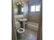 Full bathroom with tiled walls, a pedestal sink, toilet, and combined shower and bathtub at 1226 N Brunnell Pkwy, Lakeland, FL 33805