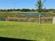 View of the backyard and pond, enclosed by a black aluminum fence at 1280 Denali Dr, Winter Haven, FL 33880