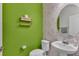 Half bathroom featuring bright green walls and patterned wallpaper at 1280 Denali Dr, Winter Haven, FL 33880