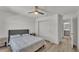 Bedroom featuring wood flooring, ceiling fan, and ensuite bath with sliding door closet at 1280 Denali Dr, Winter Haven, FL 33880