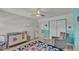 Bright bedroom featuring furnishings, neutral walls with wainscotting, ceiling fan, and wood plank floors at 1280 Denali Dr, Winter Haven, FL 33880