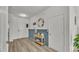 Inviting entryway with wood-look flooring, blue paneled walls, a decorative table, and a round mirror at 1280 Denali Dr, Winter Haven, FL 33880