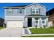 Charming two-story home with a well-manicured lawn and a two-car garage, freshly painted in blue at 1280 Denali Dr, Winter Haven, FL 33880