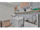 Well-equipped laundry room featuring a utility sink, modern appliances, and decorative wallpaper at 1280 Denali Dr, Winter Haven, FL 33880