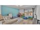 Inviting playroom with natural light, hardwood floors, play tent, blue accent wall and sofa at 1280 Denali Dr, Winter Haven, FL 33880
