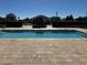 Community pool with a clear blue water and paved pool deck with outdoor space at 1280 Denali Dr, Winter Haven, FL 33880