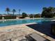 Community pool with palm trees and clear blue water, surrounded by lounge chairs at 1280 Denali Dr, Winter Haven, FL 33880