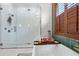 Modern bathroom featuring a glass enclosed shower and standalone tub near window with wooden shutters at 13137 Lake Butler Blvd, Windermere, FL 34786