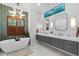 Modern bathroom featuring a standalone tub, gray vanity with double sinks, and unique lighting at 13137 Lake Butler Blvd, Windermere, FL 34786