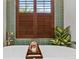 Close-up of bathtub featuring green tile accent, window with wooden shutters, and tub tray with towel at 13137 Lake Butler Blvd, Windermere, FL 34786