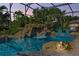 Stunning screened pool featuring a rock waterfall, spa, and lush tropical landscaping provides a serene escape at 13137 Lake Butler Blvd, Windermere, FL 34786