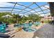 Beautiful screened pool and hot tub surrounded by lush landscaping and an outdoor seating area at 13137 Lake Butler Blvd, Windermere, FL 34786
