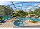 Inviting screened pool and hot tub surrounded by lush landscaping and an outdoor seating area at 13137 Lake Butler Blvd, Windermere, FL 34786