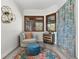 Cozy sitting area with plush chair, ottoman, and colorful rug near windows with wooden shutters at 13137 Lake Butler Blvd, Windermere, FL 34786