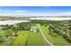Aerial view of a stunning property with a well-maintained house, manicured lawn, mature trees, and a beautiful lake at 150 Berkley Knights Dr, Auburndale, FL 33823