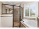 This beautiful bathroom features a walk-in shower, soaking tub, and bright shuttered window at 150 Berkley Knights Dr, Auburndale, FL 33823