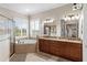 Luxurious primary bathroom featuring a glass shower, soaking tub, and double vanity sinks at 150 Berkley Knights Dr, Auburndale, FL 33823
