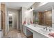 Bright bathroom featuring double sinks, a large mirror with modern lighting, and a glass-enclosed shower at 150 Berkley Knights Dr, Auburndale, FL 33823