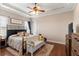 Bedroom with tray ceilings, wood floors, and a flat screen television at 150 Berkley Knights Dr, Auburndale, FL 33823