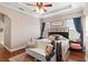 Cozy bedroom with tray ceilings, wood floors, and large windows at 150 Berkley Knights Dr, Auburndale, FL 33823
